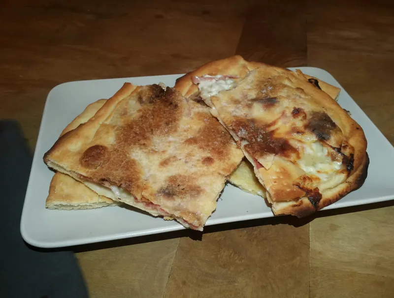 Pezzi di focaccia ripiena di stracchino e prosciutto crudo