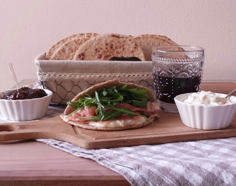 Piadine integrali appena cotte, impilate sul piano di lavoro