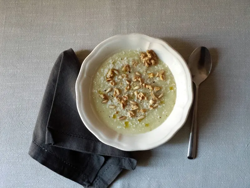 Vellutata di cavolfiore con noci, pinoli e parmigiano nel piatto