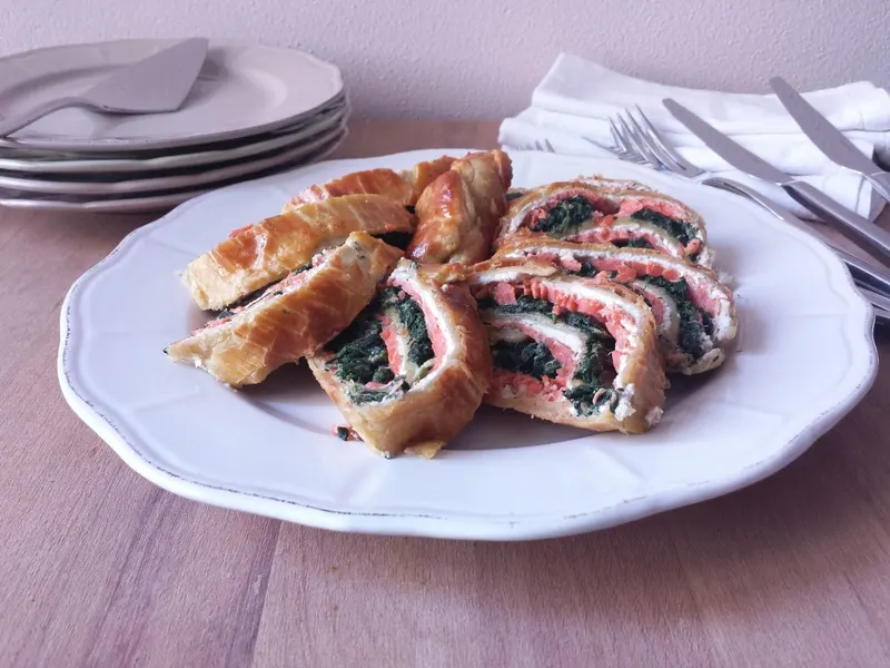 Rotolo di pasta sfoglia con salmone e spinaci appena sfornato