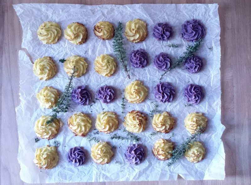 Pommes duchesse al timo chiare e viola disposte sulla teglia