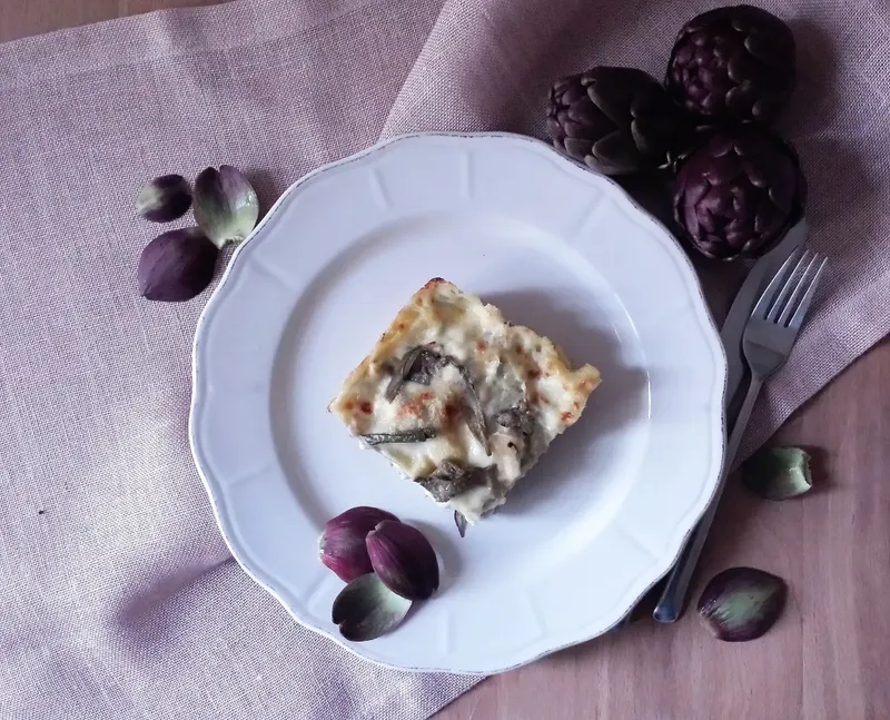 Una porzione di lasagne di carciofi e salsiccia nel piatto