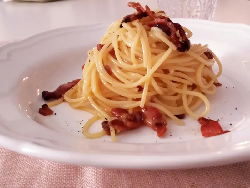 Spaghetti alla carbonara con guanciale croccante nel piatto