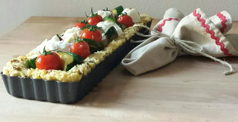 Una fetta di crostata di riso con verdure e burrata
